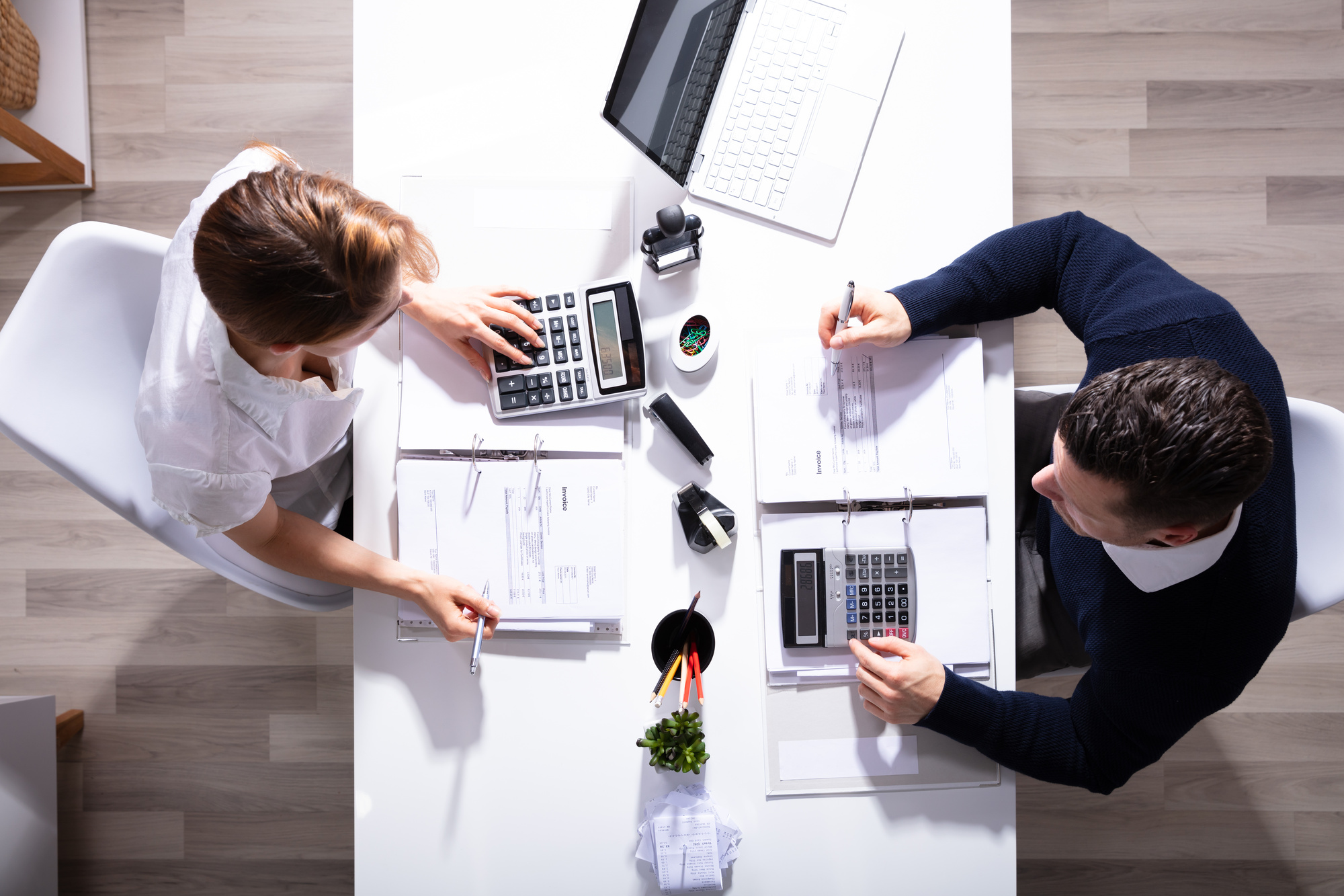 male_and_female_businesspeople_calculating_invoice